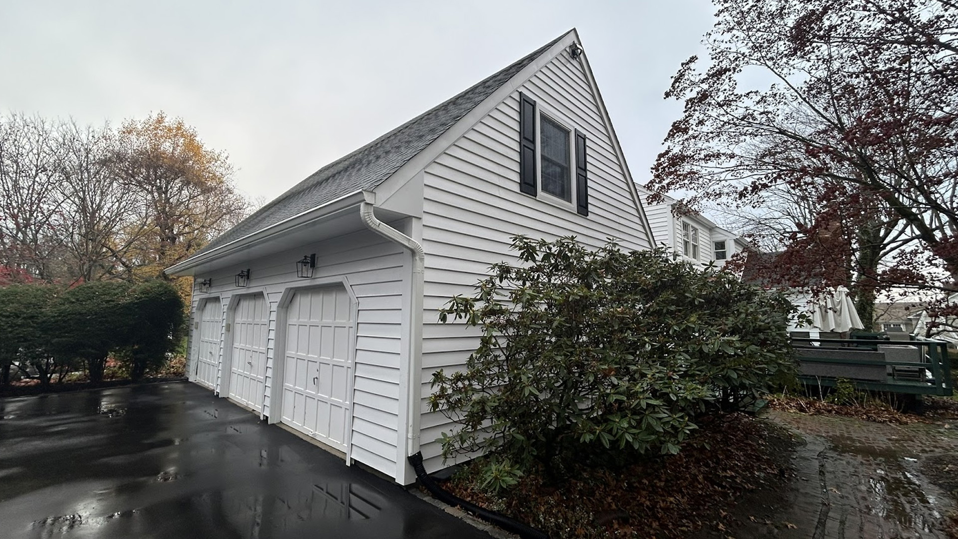 Freshly cleaned white siding and garage doors on a Long Island home