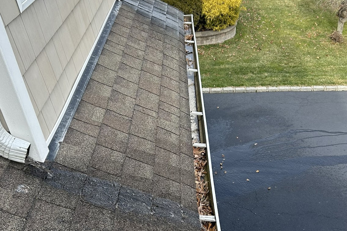 Looking down at a clean gutter and downspout system during gutter cleaning in Long Island.