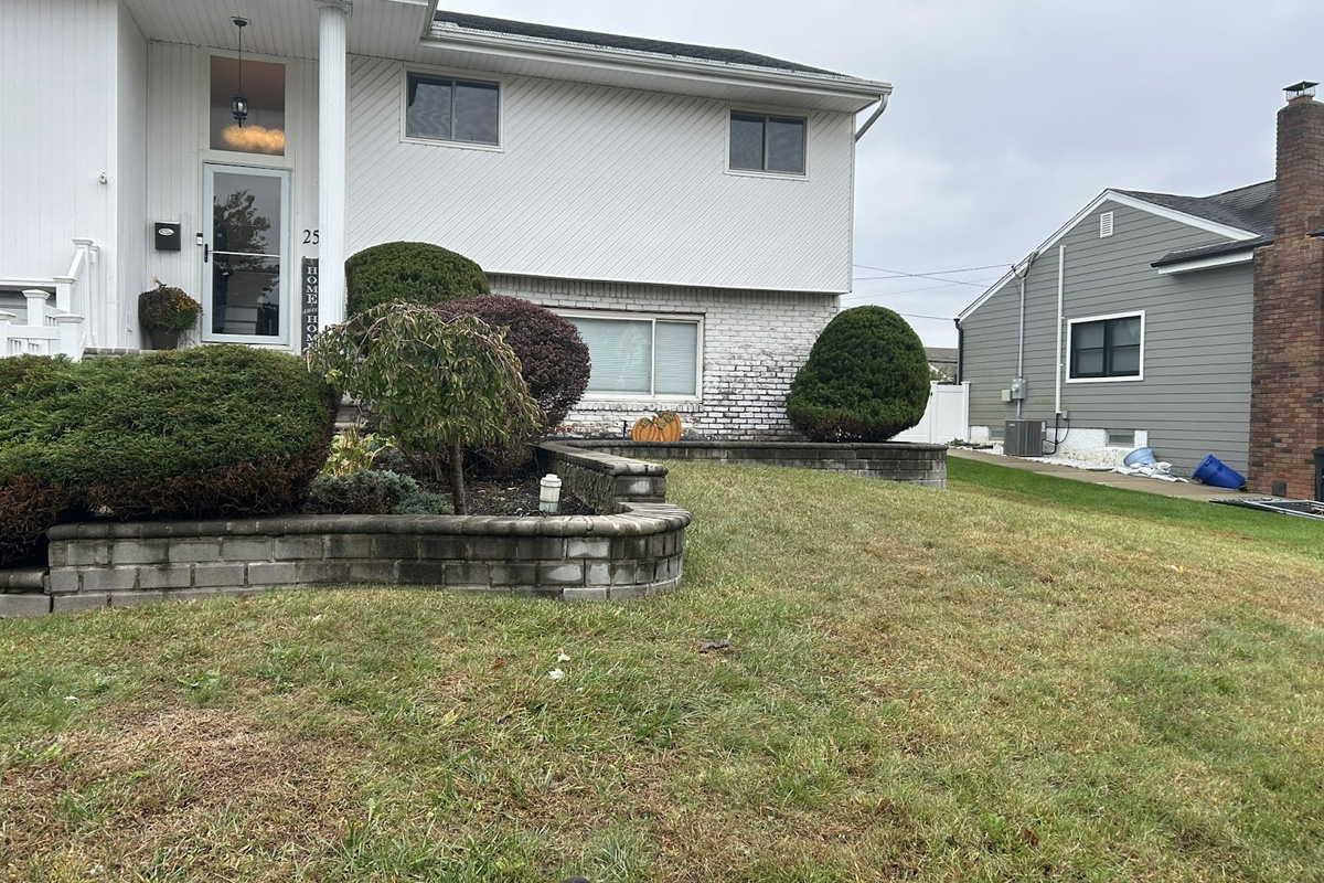 Clean stone retaining wall and driveway after professional power washing in Long Island.