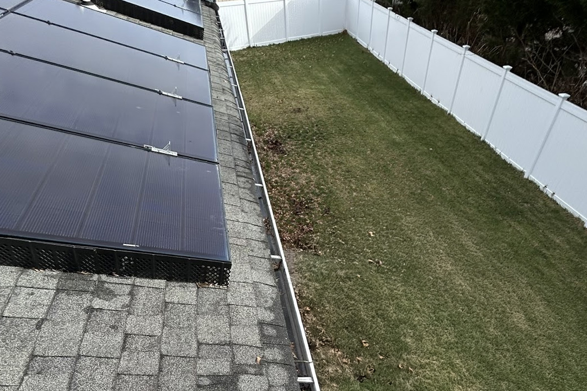 Solar panels and shingle roof during a detailed exterior cleaning services in Long Island.